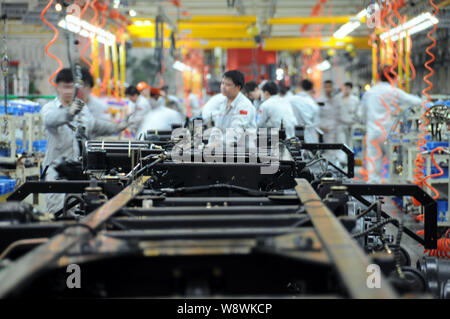 --FILE--lavoratori cinesi preparare parti sulla linea di montaggio di autocarri pesanti in un impianto automatico di Dongfeng Commercial Vehicle Co. nella città di Shiyan, centrale Foto Stock