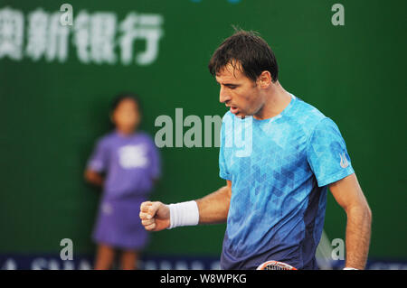 Ivan Dodig di Croazia celebra dopo il punteggio contro Pablo Cuevas del Uruguay nel primo round di uomini singoli durante il 2014 Shanghai Rolex Foto Stock