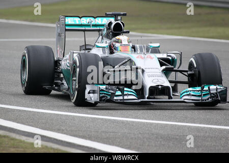 British F1 driver Lewis Hamilton di Mercedes manzi la sua vettura durante una sessione di prove libere in vista del 2014 Formula Uno Gran Premio di Cina a Shanghai Foto Stock