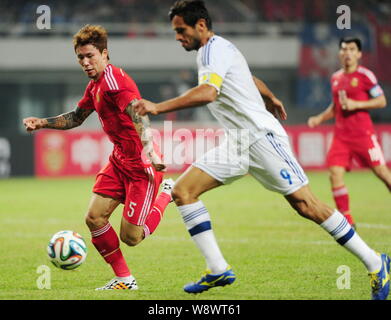 Zhang Linpeng della Cina, sinistra, sfide Roque Santa Cruz del Paraguay durante un amichevole partita di calcio nella città di Changsha, centrale cinese di Hunan provinc Foto Stock