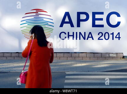 Una passeggiate a piedi passato un cartello per la Cina APEC 2014 a Pechino, in Cina, il 2 novembre 2014. In Cina il martedì (4 novembre 2014) premuto il suo caso Foto Stock