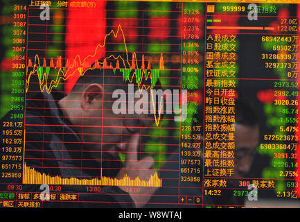 In questo multi-immagine di esposizione, investitori cinesi guardare preoccupati guardano allo Shanghai indice composito in corrispondenza di un magazzino casa di brokeraggio in città Fuyang, Foto Stock