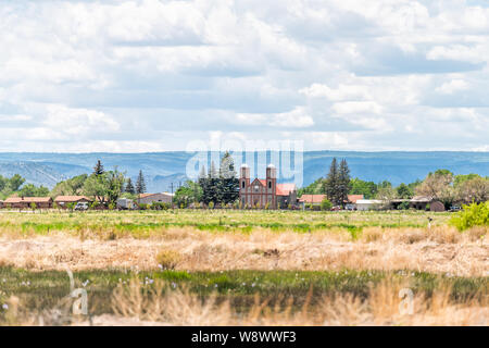 Autostrada 285 con cityscape di Conejos e la chiesa più antica di Colorado nella vecchia città vintage vicino Antonito Foto Stock