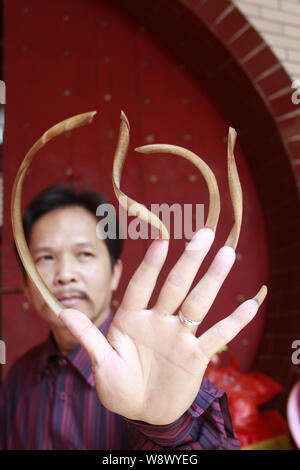 Un uomo cinese soprannominato Feng mostra fuori le sue unghie lunghe nel centro della città di Haikou, sud Chinas Hainan Provincia, 13 marzo 2011. Feng ha detto ai giornalisti che egli Foto Stock