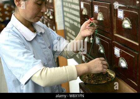 --FILE--un cinese pharmaceutist eroga la medicina tradizionale cinese in un TCM farmacia in Cina a Shanghai, 14 novembre 2011. Cinese tradizionale m Foto Stock