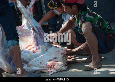 Makassar, Indonesia - Agosto 11th, 2019. Persone Processi la carne delle vacche sacrificied durante l'Eid al-Adha festival. Musulmani indonesiani e i musulmani di tutto il mondo celebrano l'Eid al-Adha Domenica a Lunedi. Il giorno santo chiamato anche la "Festa del sacrificio", è il secondo di due festività Islamiche celebrato in tutto il mondo ogni anno dopo l'Eid al-Fitr. Foto Stock