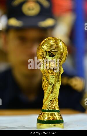 Un Cinese funzionario doganale controlla un grippaggio fake World Cup Trofeo presso un magazzino in Yiwu City East Chinas nella provincia di Zhejiang, 24 aprile 2014. 18,860 fa Foto Stock
