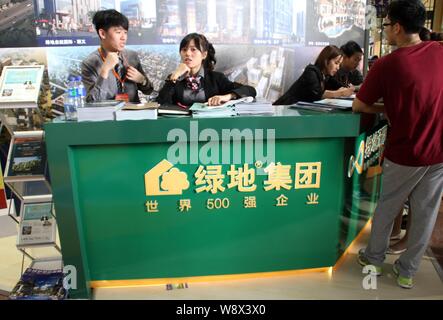 --FILE--dipendenti sono visti presso lo stand della Groenlandia un gruppo durante una fiera immobiliare a Pechino in Cina, 19 settembre 2013. Società immobiliare Greenlan Foto Stock