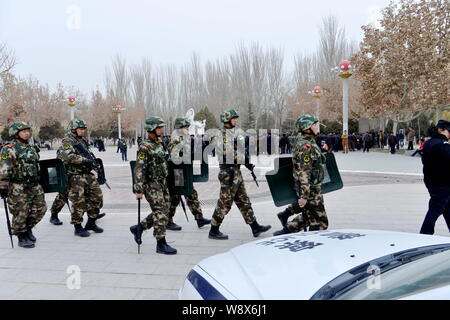 --FILE--cinese armati paramilitari pattuglia di poliziotti un parco a Kashgar, Northwest Chinas Xinjiang Uygur Regione autonoma, 3 marzo 2014. Foto Stock