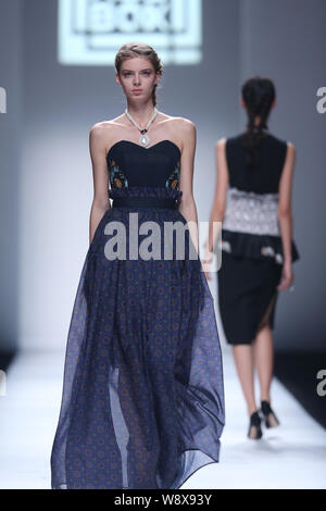 Un modello consente di visualizzare una nuova creazione al Moodbox fashion show durante la Shanghai Fashion Week Primavera/Estate 2015 in Cina a Shanghai, 20 ottobre 2014. Foto Stock