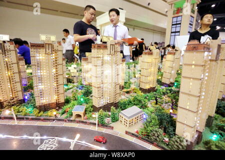 --FILE--cinese i homebuyers visualizza i modelli di alloggiamento di una proprietà residenziale di progetto a una fiera immobiliare nella Città di Zhengzhou, centrale della Cina di Henan provin Foto Stock