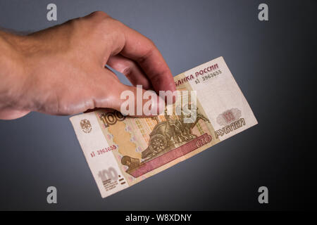 Uomo con 100 rubli russi, denaro contante Foto Stock
