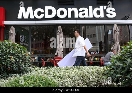 --FILE--A passeggiate a piedi passato un McDonald un fast food ristorante a Shanghai in Cina, 23 luglio 2014. McDonald's Corp. è l'arruolamento di Orchi e Elfi Foto Stock