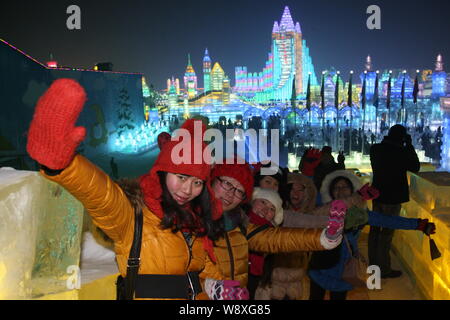 Visitatori posano per le foto di fronte a sculture di ghiaccio al trentesimo Harbin International Ice e Snow Festival di Harbin city, nordest Chinas Heilongjia Foto Stock