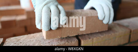 Mani maschio mettendo mattone Foto Stock