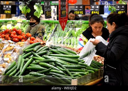 --FILE--i clienti cinesi shop per ortaggi in un supermercato nella città di Qiqihar, nordest Chinas Provincia di Heilongjiang, 9 marzo 2014. Chinas inflati Foto Stock