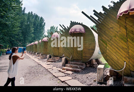 Una donna cinese prende le foto di hotel con camere realizzate da industriali di tubi di calcestruzzo al tubo di cemento Hotel in Ruyang county, porcellane centrale provincia di Henan Foto Stock