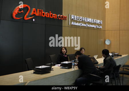 --FILE--dipendenti cinesi servono visitatori presso il banco del ricevimento in sede di Alibaba (Cina) Technology Co., Ltd. in Hangzhou, est mento Foto Stock