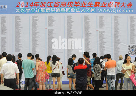 --FILE--laureati cinesi guardare le informazioni di lavoro a una fiera del lavoro in Hangzhou, est Chinas nella provincia di Zhejiang, 7 giugno 2014. Un record di 7,27 Foto Stock