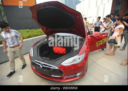 --FILE -- gente guarda a un modello di Tesla S auto elettrica nella città di Wuhan, porcellane centrale provincia di Hubei, 13 giugno 2014. Tesla Motors Inc., elettro-car Foto Stock