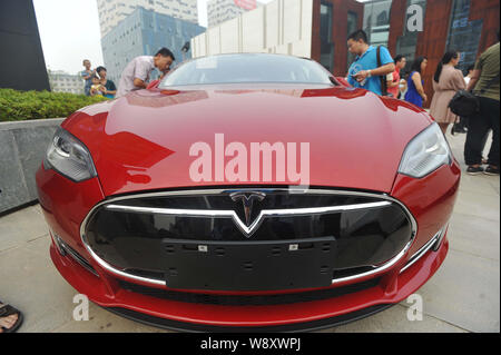 --FILE -- gente guarda a un modello di Tesla S auto elettrica nella città di Wuhan, porcellane centrale provincia di Hubei, 13 giugno 2014. La Cina sta continuando la sua marcia di ele Foto Stock