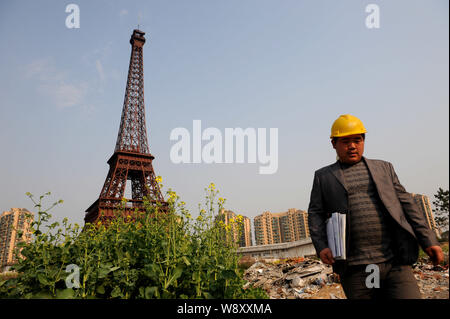 --FILE--un lavoratore cinese passeggiate oltre la metà dimensioni copia della Torre Eiffel a Tianducheng, una piccola comunità cinese la replica di Parigi, nella città di Hangzhou, Foto Stock