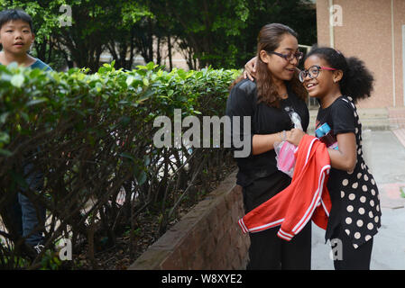 Cinese ragazza africana Xiao Xiao, destra, abbracci la madre dopo la scuola nella città di Guangzhou, Cina del sud della provincia di Guangdong, 21 novembre 2014. Poiché Chi Foto Stock