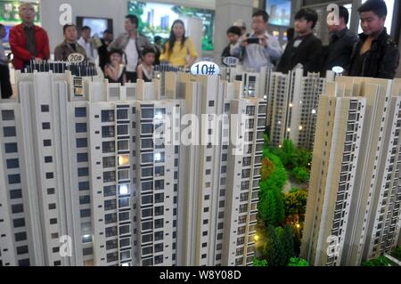 --FILE--cinese i homebuyers guardare a modelli di appartamento residenziale edifici durante una fiera immobiliare in Cina a Shanghai, il 2 maggio 2014. Un capo di stato Foto Stock