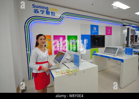 --FILE--un dipendente viene visto in un negozio fisico di shopping online del sito web di Suning.com Suning Gruppo in Cina a Shanghai, 25 aprile 2014. Suning Comm Foto Stock