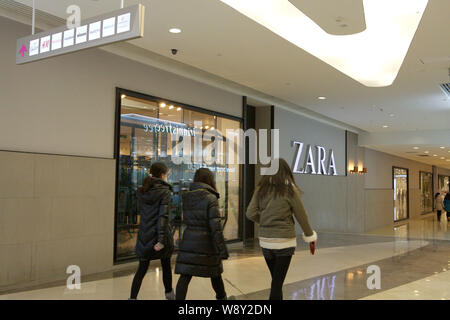 --FILE--pedoni a piedi passato un negozio di Zara presso un centro commerciale a Pechino, in Cina, il 7 gennaio 2014. Fast marchi di moda hanno rapidamente emerse a w Foto Stock