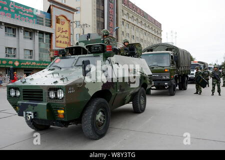 --FILE--cinese poliziotti paramilitari pattugliare una strada da veicolo a Kashgar, Northwest Chinas Xinjiang Uygur Regione autonoma, 30 luglio 2014. Foto Stock