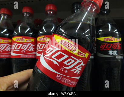 --FILE--un cliente acquista una bottiglia di Coca Cola in un supermercato a Yichang city, porcellane centrale provincia di Hubei, 17 aprile 2013. Coca Cola venduta in meno Foto Stock