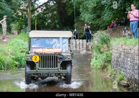 Lacock, Wiltshire, Regno Unito. 11 agosto 2019. Nonostante il meteo unseasonal centinaia di persone frequentano il veicolo militare e rievocazione Show a Lacock Foto Stock