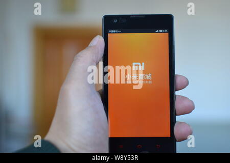 --FILE--un cinese telefono cellulare utente guarda un logo di Xiaomi sul suo smartphone nella città di Qiqihar, porcellane del nord della provincia di Heilongjiang, 10 novembre 2014. Foto Stock