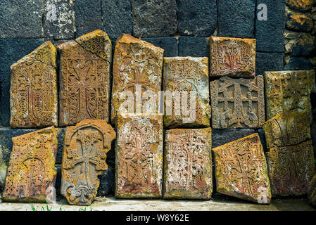 Close-up di pietre antiche khachkars intagliate con motivi di pizzo sulle pareti di un monastero in Armenia Foto Stock