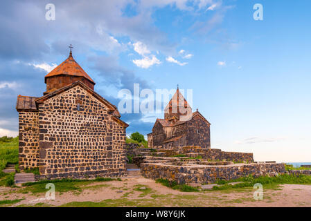 L'architettura del famoso monastero armeno Sevanavank i raggi del sole al tramonto Foto Stock