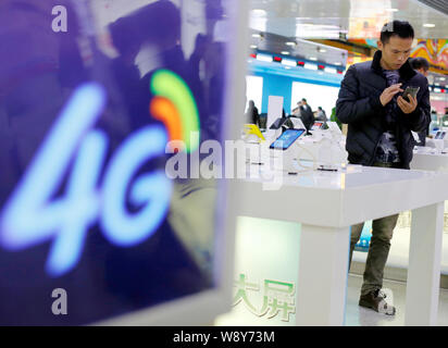 --FILE--un cliente cinese tenta di eseguire un 4G supportati smartphone a un ramo di China Mobile in Hangzhou, est Chinas nella provincia di Zhejiang, 2 Dicembre Foto Stock