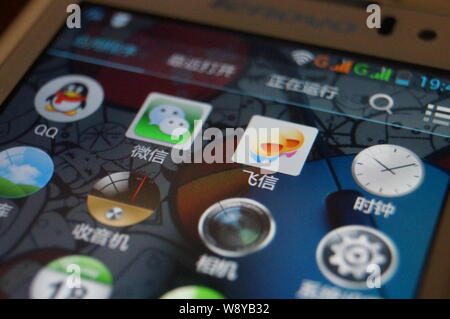 --FILE--un cinese telefono cellulare utente guarda le icone della messaggistica mobile apps QQ di Tencent, Weixin o WeChat, di Tencent e Fetion della Cina Foto Stock