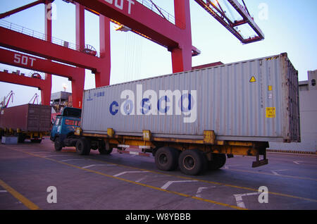 --FILE -- un carrello che trasporta un contenitore di COSCO su una banchina del porto di Rizhao nella città di Rizhao, est Chinas provincia di Shandong, 5 aprile 2014. L'HEA Foto Stock