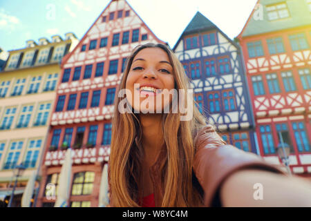 Bella donna sorridente prendere ritratto di auto in Piazza Romerberg a Francoforte, Germania Foto Stock