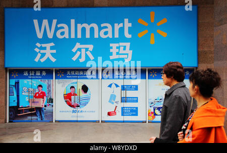 --FILE--pedoni a piedi passato un supermercato Walmart a Chongqing Cina, 16 novembre 2013. Wal-Mart Stores Inc. ha detto che triplicherà la sua spesa per Foto Stock