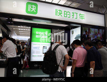 --FILE -- la gente visita lo stand della prenotazione taxi app Kuaidi Dache di Alibaba durante una mostra a Shanghai in Cina, 24 luglio 2014. Il pagamento online Foto Stock