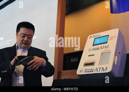 Bobby Lee, CEO di BTC Cina, dimostra il funzionamento di porcellane primo BitCoin ATM a un evento di lancio in Cina a Shanghai, 15 aprile 2014. Un Cinese c Foto Stock