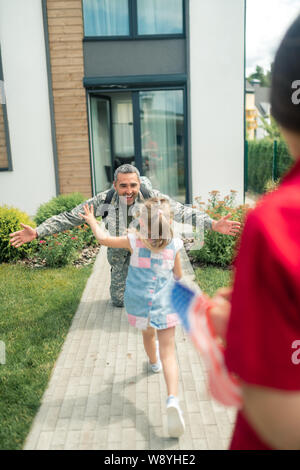 Padre felice di ritornare a casa dopo un anno e mezzo di servizio Foto Stock