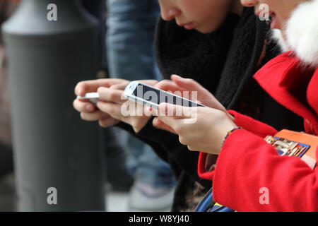 --FILE-Young le donne cinesi utilizzano il loro smartphone per navigare in Internet a un parco nella città di Nantong, est Chinas provincia dello Jiangsu, 23 novembre 2013. Ch Foto Stock