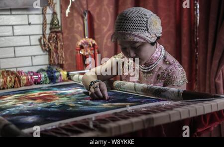 Il 35-anno-vecchio Yang Xiaoting cuciture sul suo lavoro di ricamo presso il suo studio di ricamo nella città di Wuhan, Cina centrale della provincia di Hubei, 2 luglio 2014. Yang Foto Stock