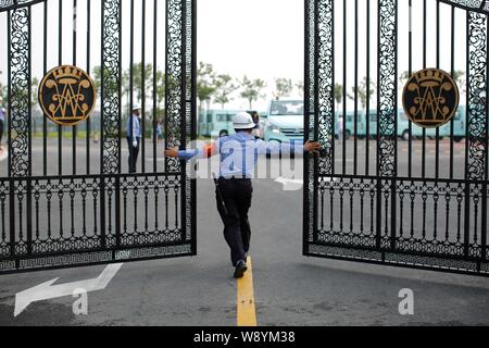 Una guardia di sicurezza si apre il cancello di Wellington Collegio Internazionale di Shanghai Pudong, Shanghai, Cina, 25 agosto 2014. La recente apertura del Wellington Foto Stock