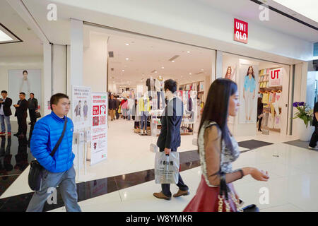 --FILE--pedoni a piedi passato un negozio di Uniqlo nella città di Fuzhou, sudest Chinas provincia del Fujian, 22 marzo 2014. Se mai ci fosse un poster chi Foto Stock