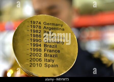 Un Cinese funzionario doganale controlla un grippaggio fake World Cup Trofeo presso un magazzino in Yiwu City East Chinas nella provincia di Zhejiang, 16 aprile 2014. Più di Foto Stock