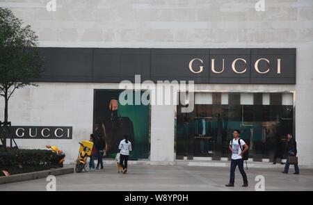 --FILE--i clienti a piedi passato una boutique di marca di lusso Gucci nella città di Nanjing East Chinas provincia dello Jiangsu, 8 novembre 2013. Beni di lusso, borse, clo Foto Stock